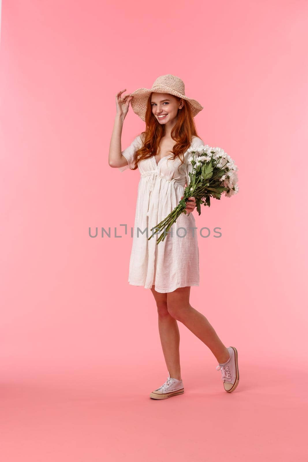 Full-length vertical shot sassy and happy, smiling redhead female walking with her date along streets, coquettish grinning, touching straw hat on head, holding beautiful flowers, receive bouquet by Benzoix
