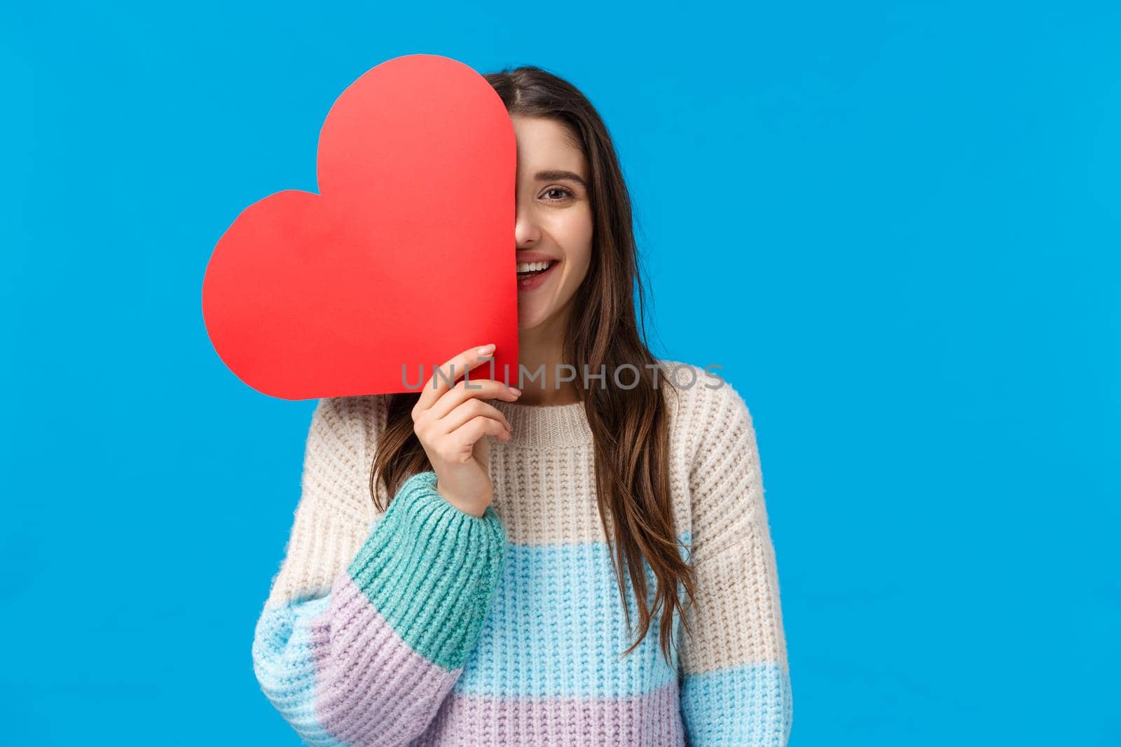 Time to say i love you. Cheerful dreamy and cute caucasian brunette woman cover half face with big red heart sign, smiling, express affection and symapthy on valentines day, receive cute present.