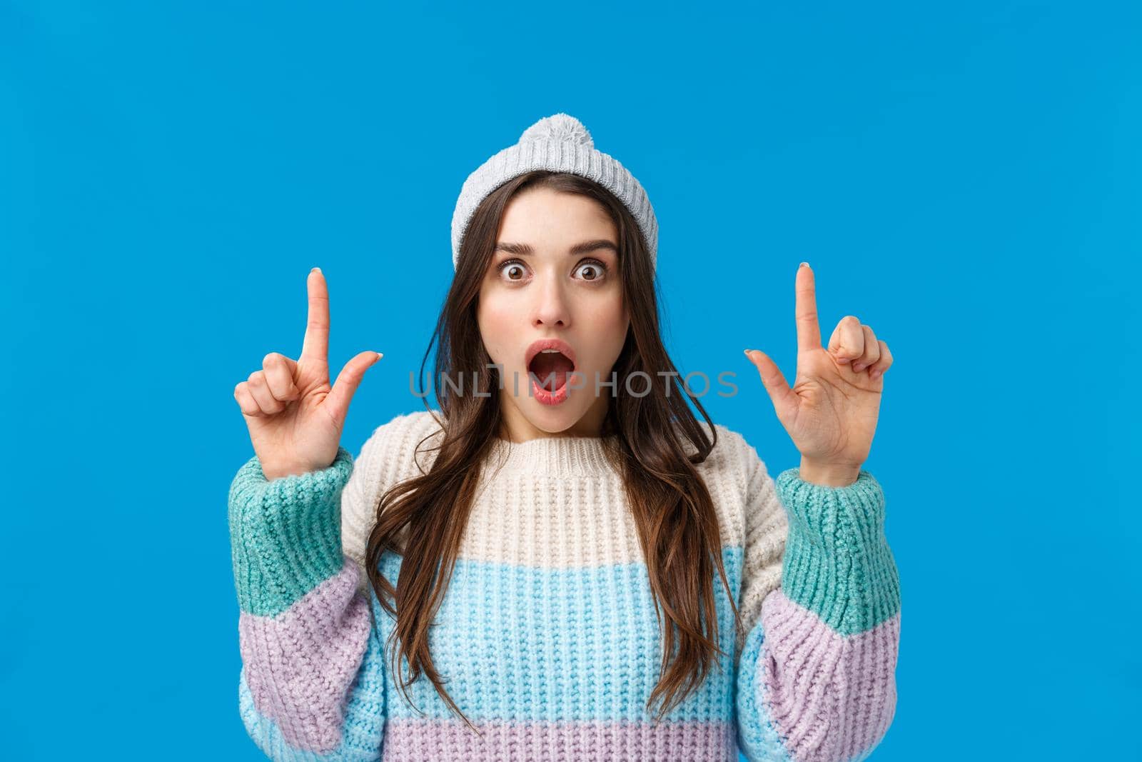 Check this out, omg. Astonished and excited girl, shopaholic found excellent discounts special for students, shopping winter holidays, gasping drop jaw staring camera and pointing fingers up.