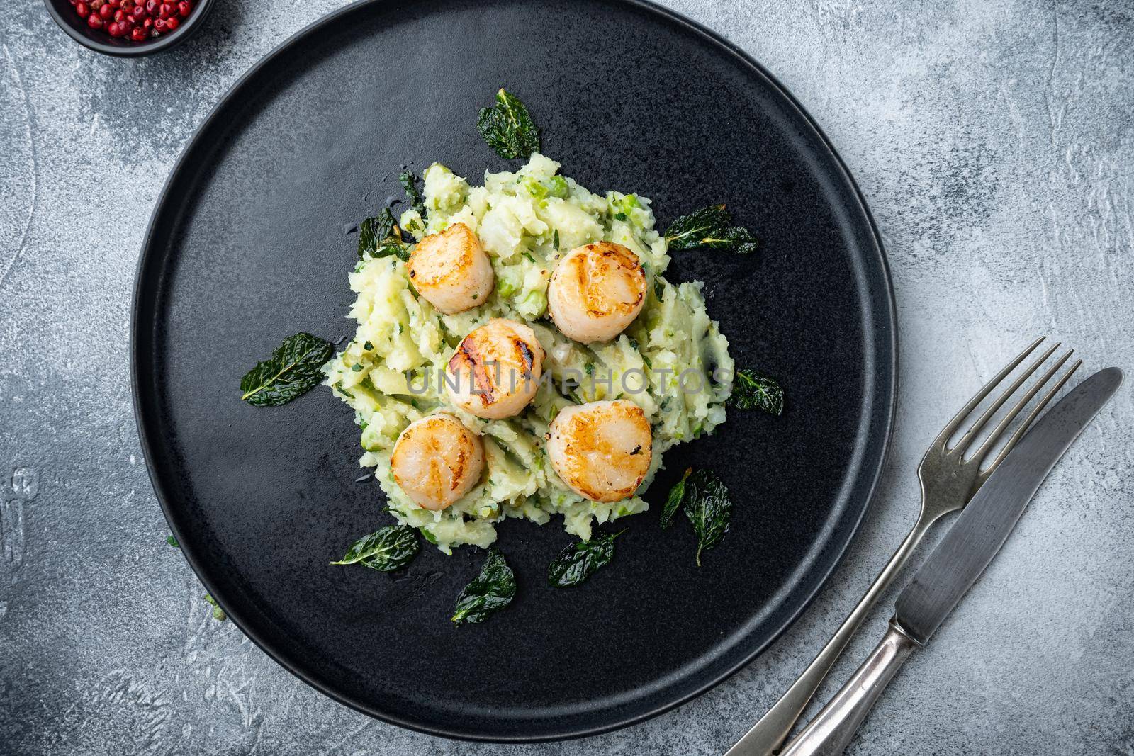 Sea delicacies, scallops cooked with minty puree, flat lay, on grey background