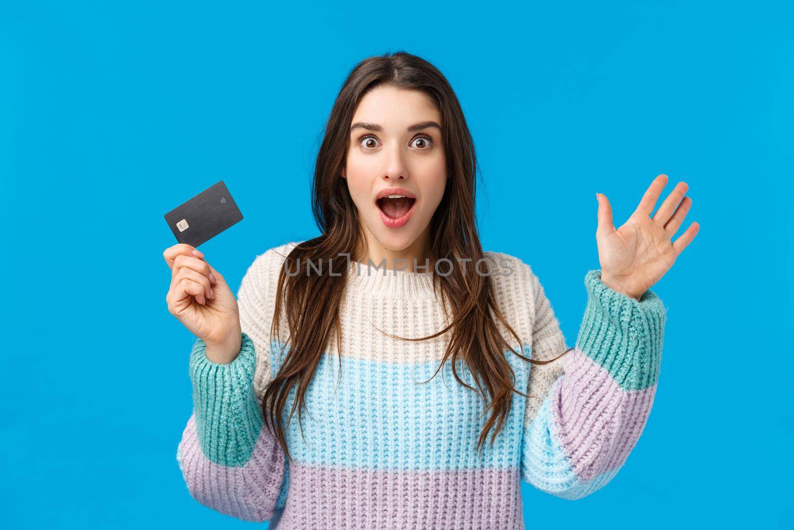 Girl telling about awesome news, explaining something passionetly and excited, gesturing holding credit card, cant express amazement and joy, seeing something breathtaking, say take my money.