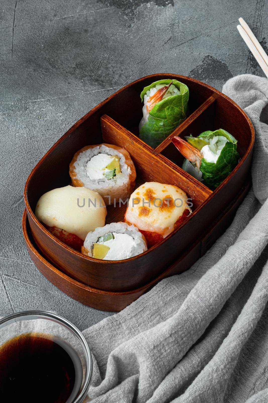 Japanese bento lunch box with chopsticks, on gray stone background by Ilianesolenyi