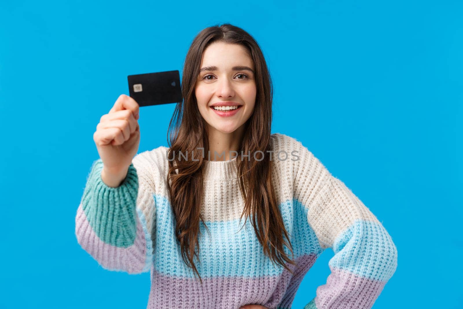 Best bank for young generation. Attractive pleased charismatic young woman in winter sweater, showing credit card and smiling satisfied, recommend financial system, new banking features by Benzoix