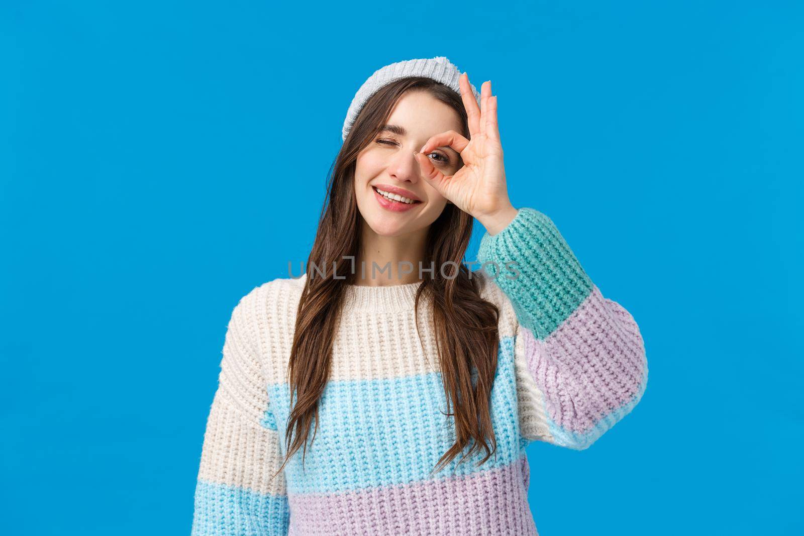 Okay, no problem everything be good. Cheerful and cute relaxed young woman enjoying winter holidays, showing ok, excellent gesture, looking through fingers and wink, happy smiling, all alright.