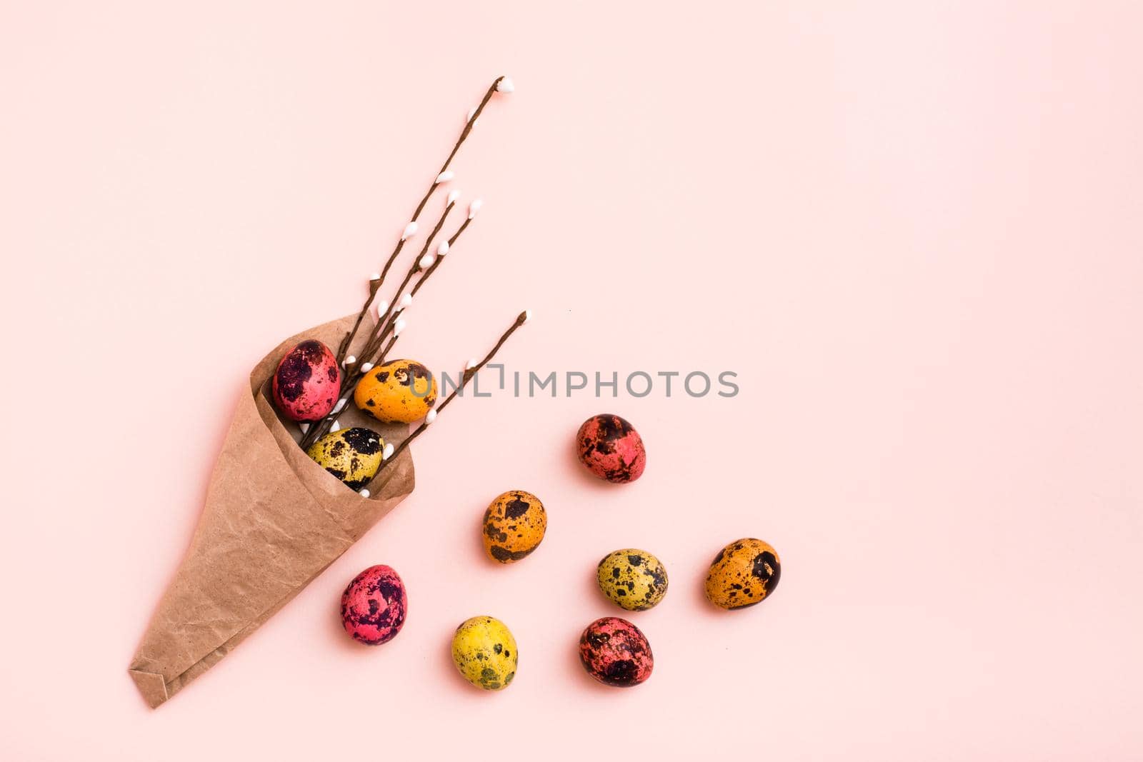 Happy Easter. Painted quail eggs and pussy willow in wrapping paper on pink background by Aleruana