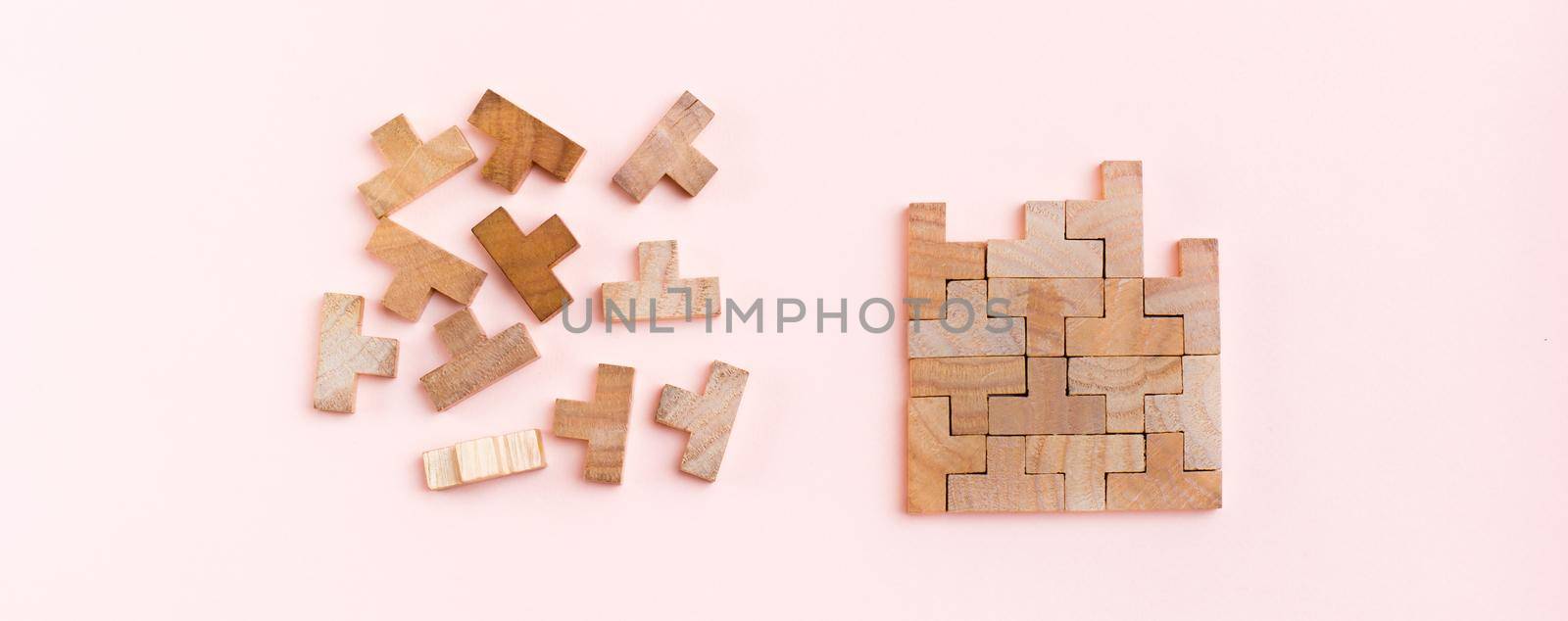 Organization and order. Wooden puzzle pieces are stacked correctly and chaotically scattered in disarray on a pink background. Web banner