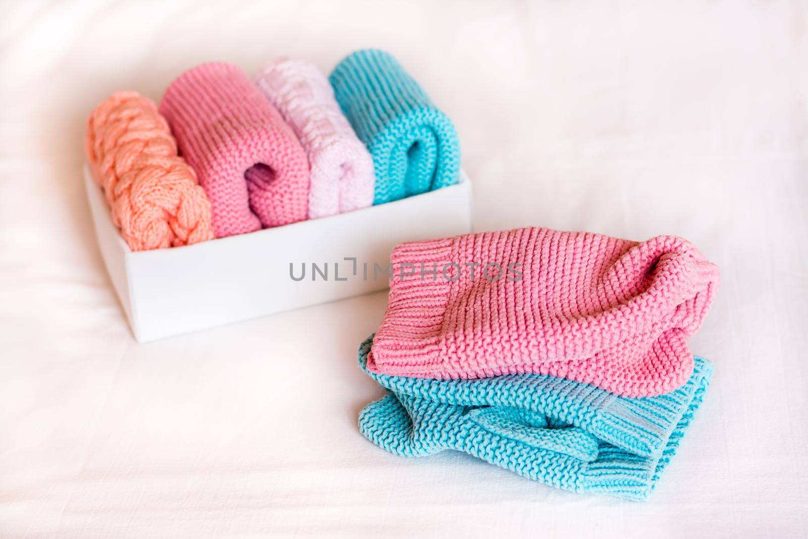Organization and order. Knitted clothes lie next to a box of neatly folded things.
