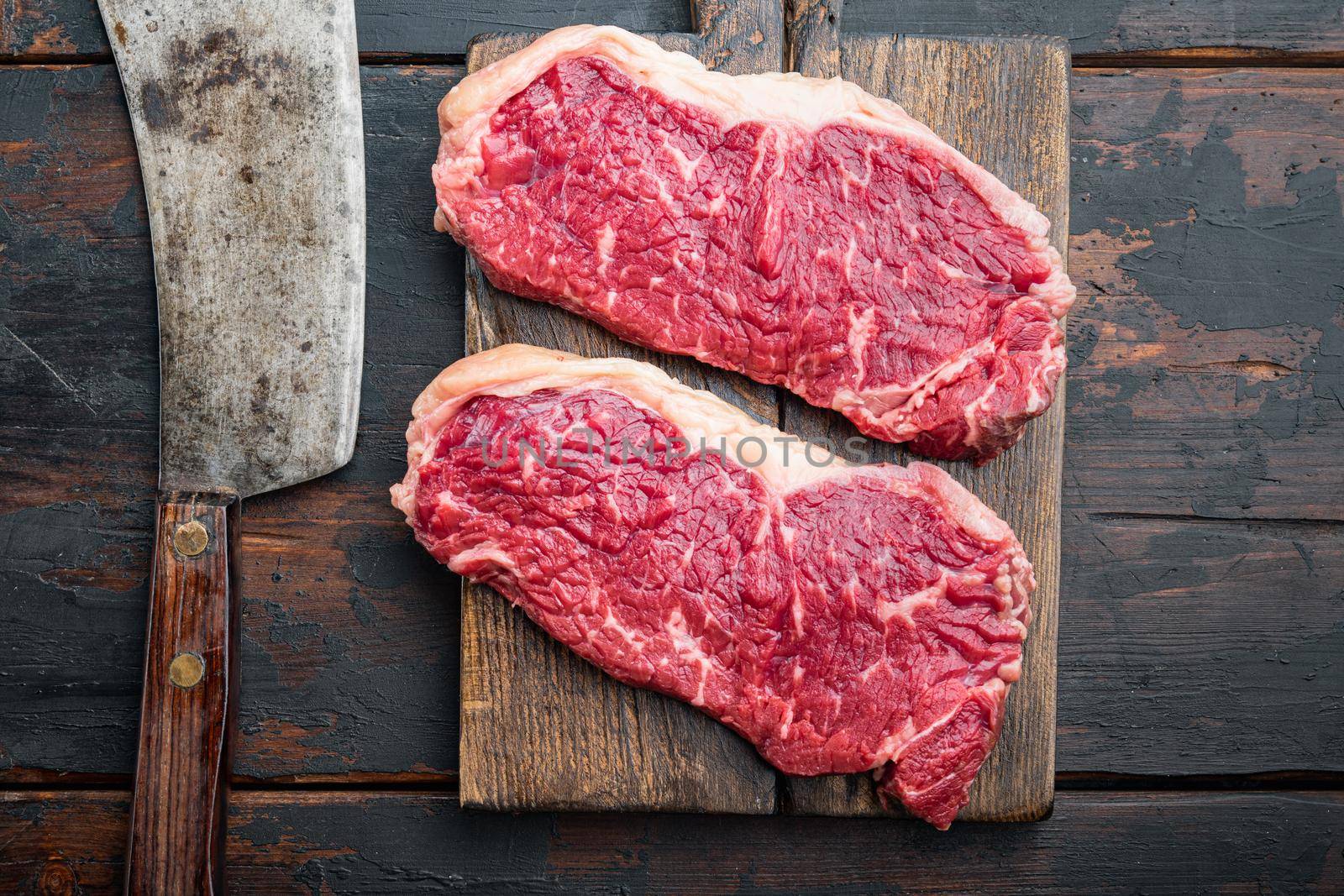 New York steak raw beef meat, on dark wooden background, top view