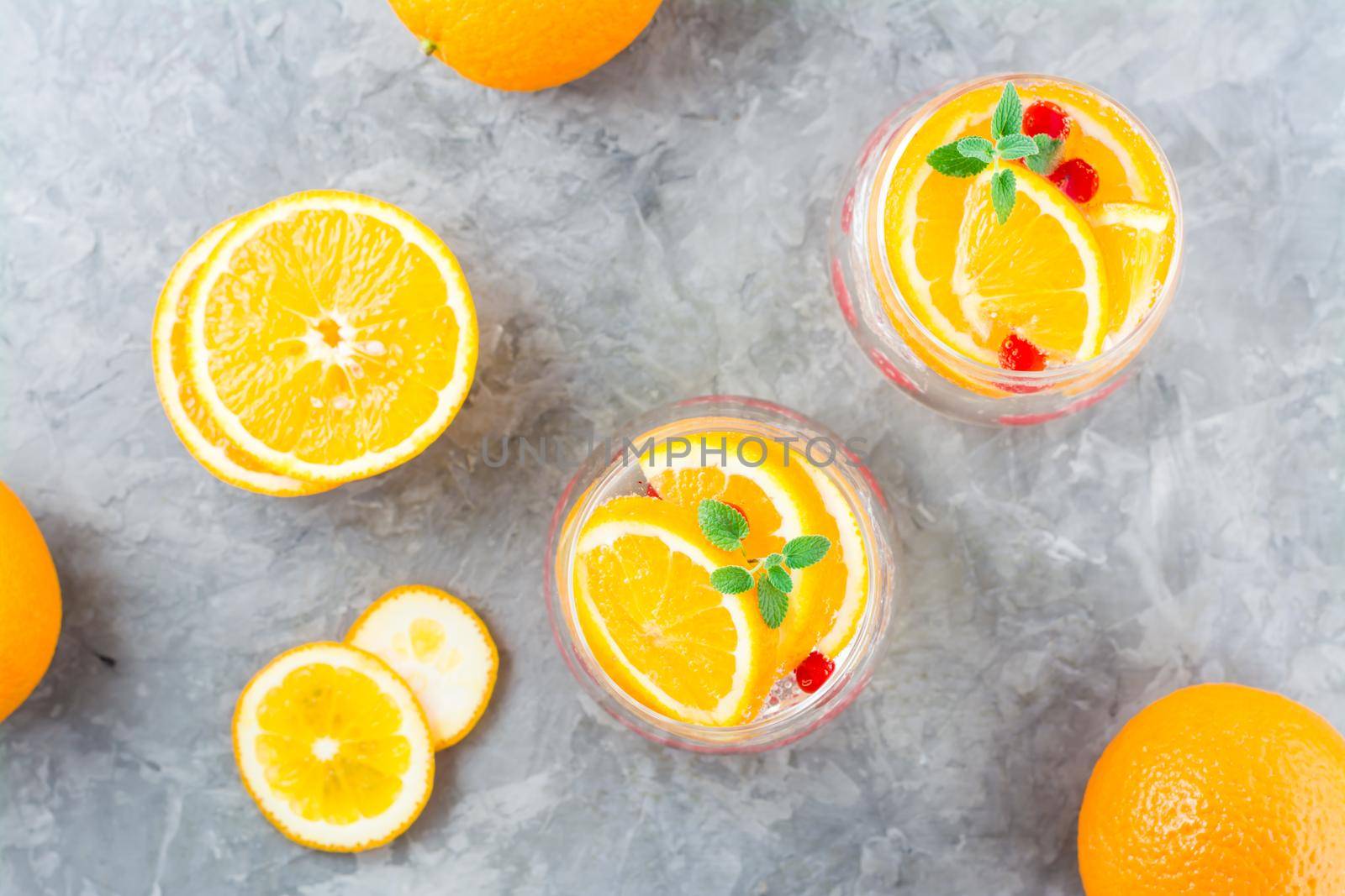 Hard seltzer cocktail with orange, cranberry and mint in glasses on the table. Alcoholic beverage. Top view
