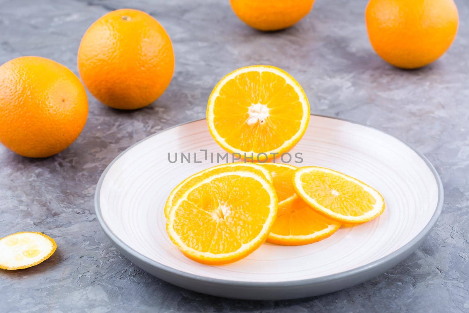 Pieces of fresh orange on a plate on the table. Vitamins, diet and vigor by Aleruana