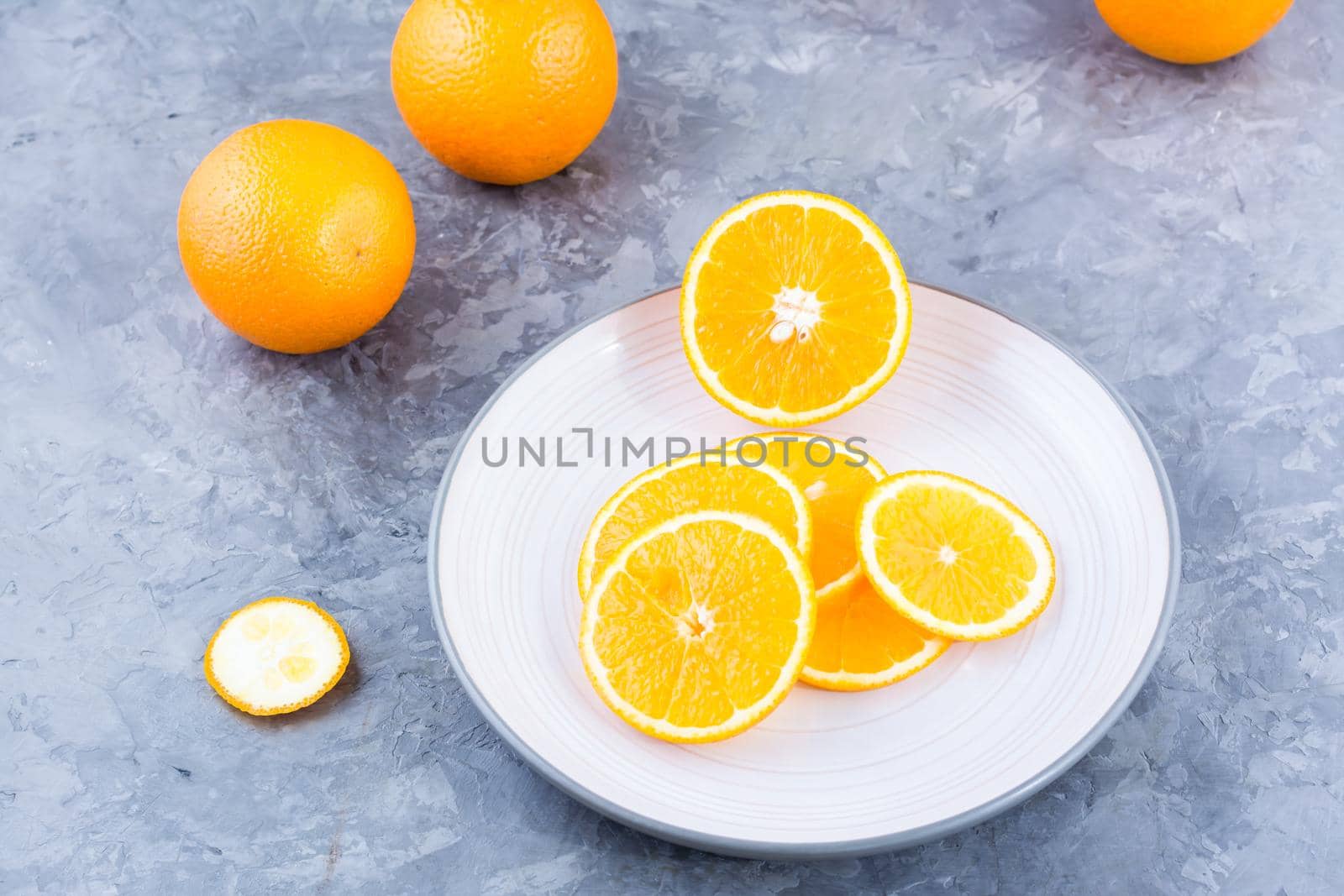 Pieces of fresh orange on a plate on the table. Vitamins, diet and vigor. Healthy eating by Aleruana