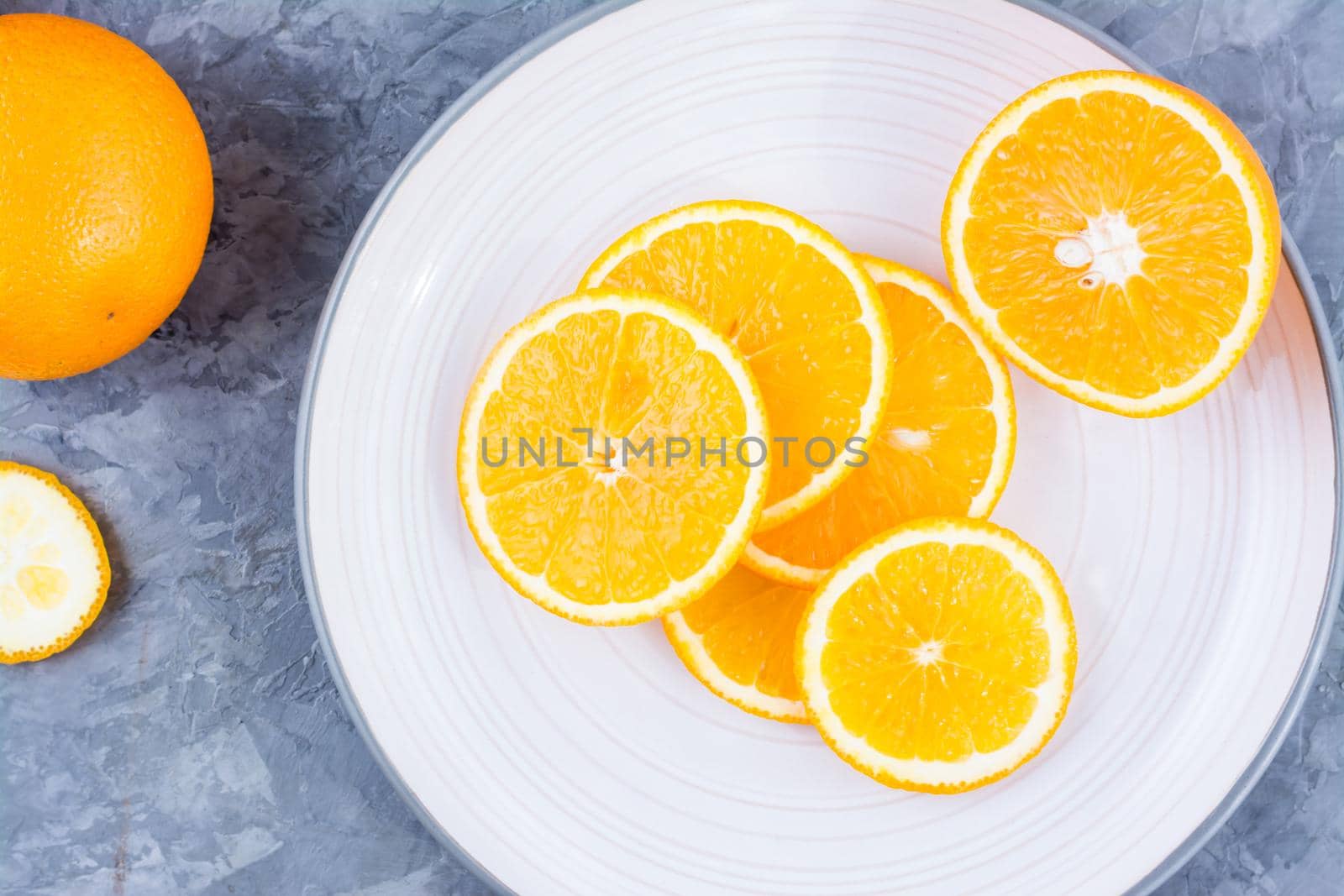 Pieces of fresh orange on a plate on the table. Vitamins, diet and vigor. Close-up by Aleruana