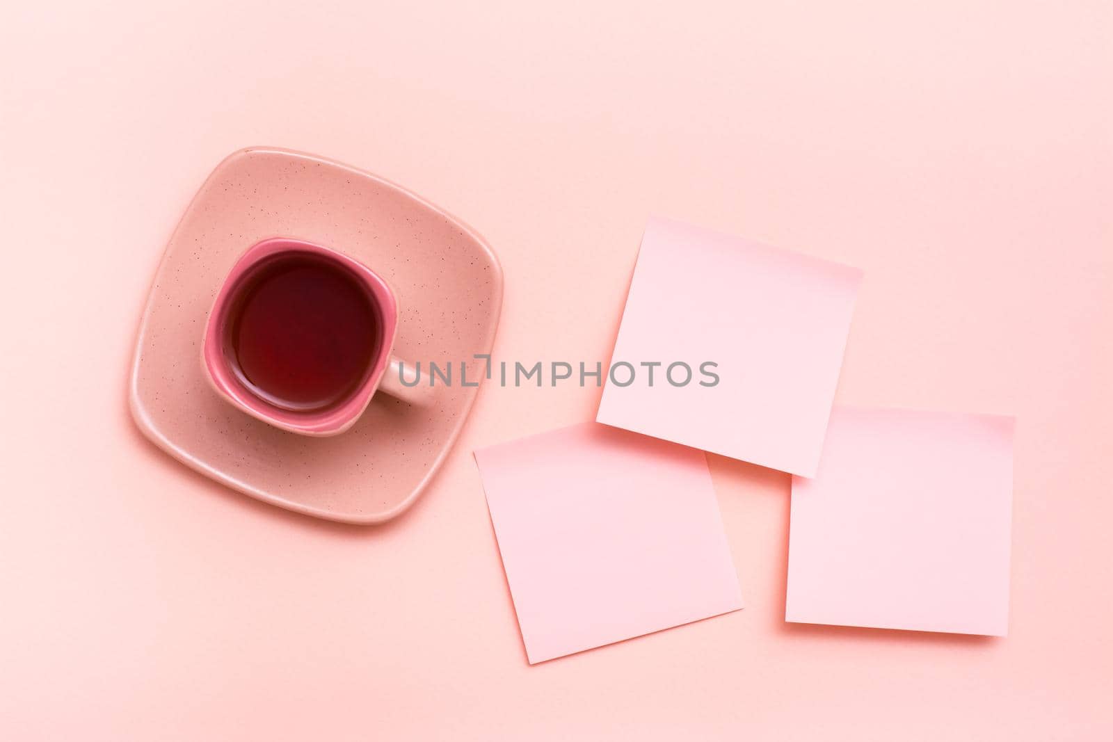 The concept is pink. Pink drink in a coffee cup and sheets for writing on a pink background. Top view