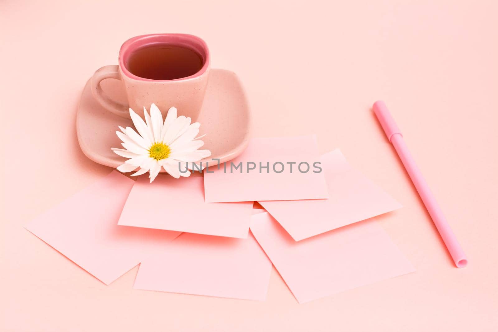 The concept is pink. Pink drink in a coffee cup, sheets for writing, a pen and a chrysanthemum on a pink background. by Aleruana