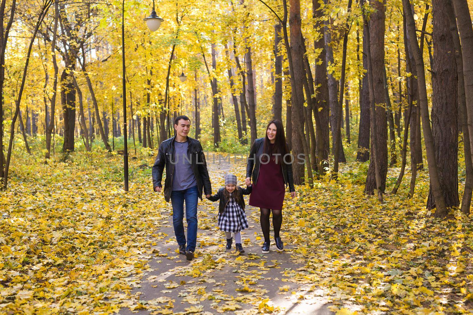 Fall, nature and family concept - family walking in autumn park