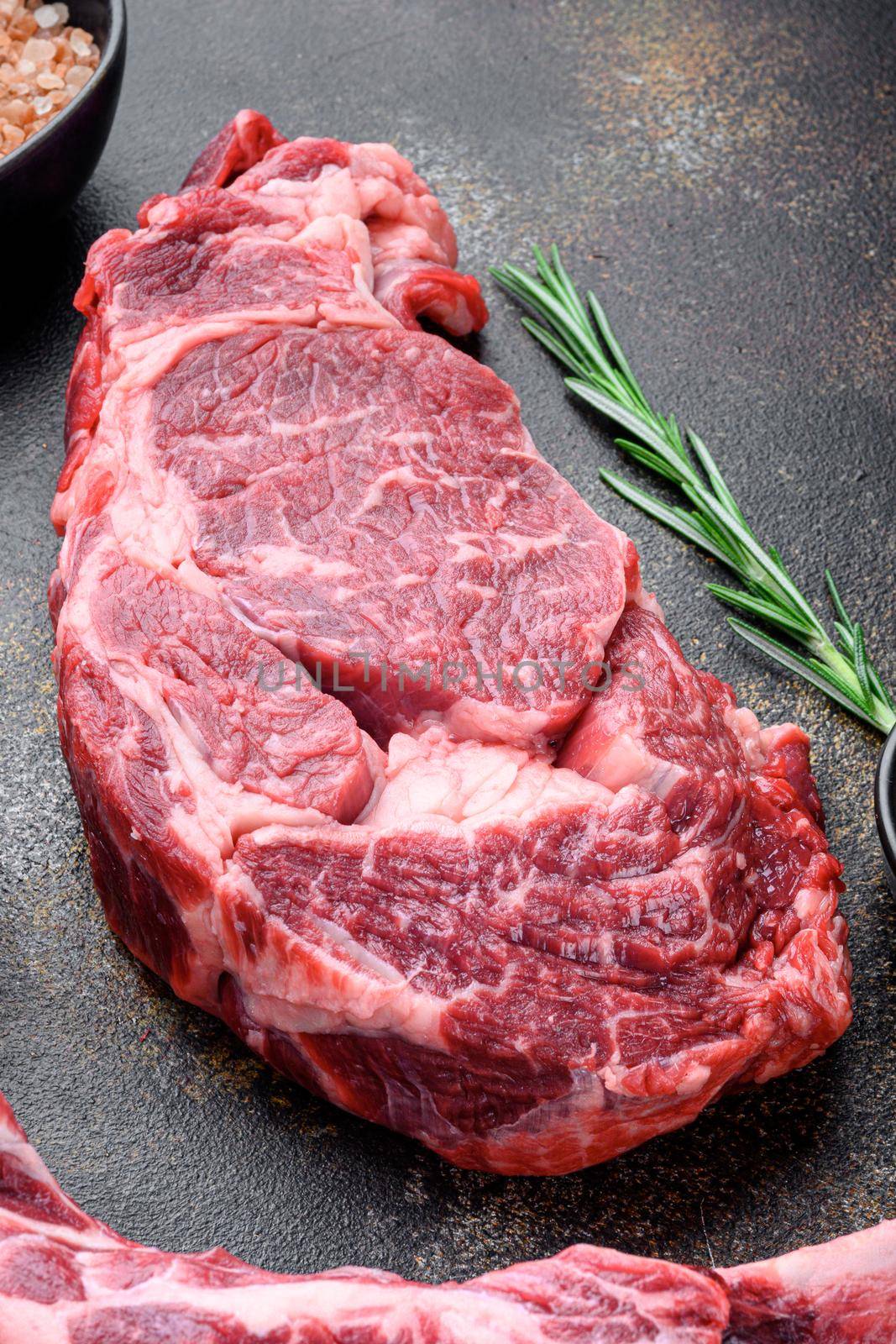 Rib eye steak fresh raw beef marbled prime meat ribeye set, on old dark rustic background