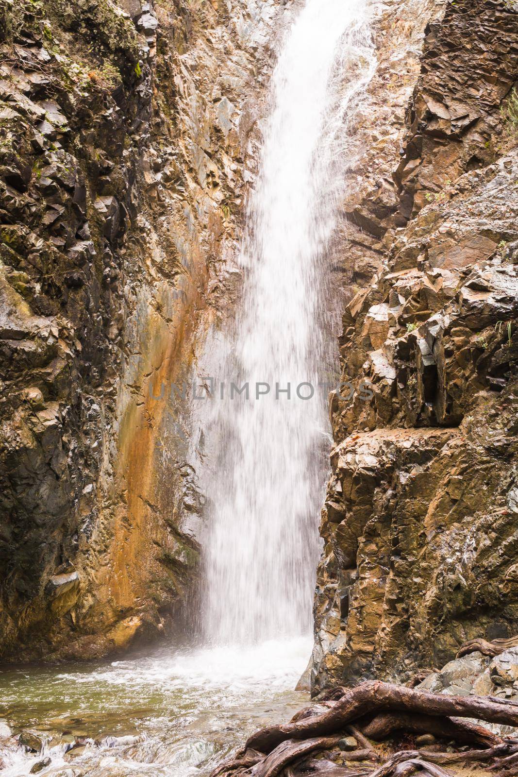 Autumn waterfall with rocks and leaves in Troodos mountains in Cyprus.