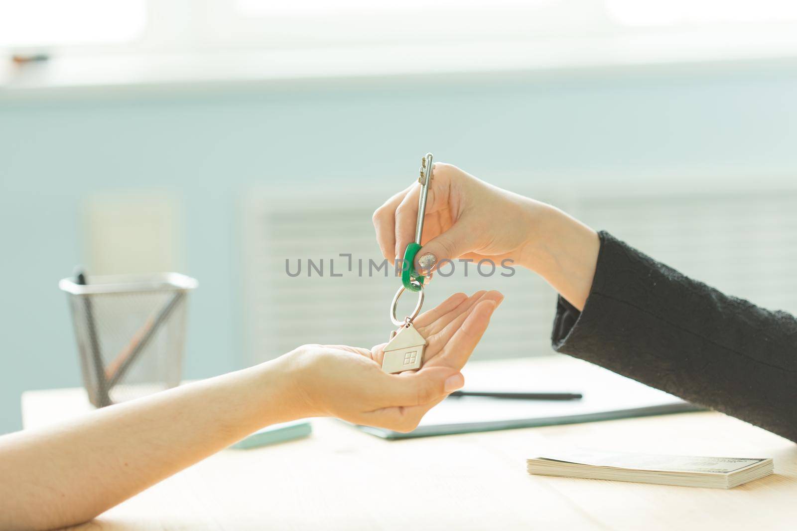 Business, realtor and real estate concept - Hand-to-hand key from new home by Satura86
