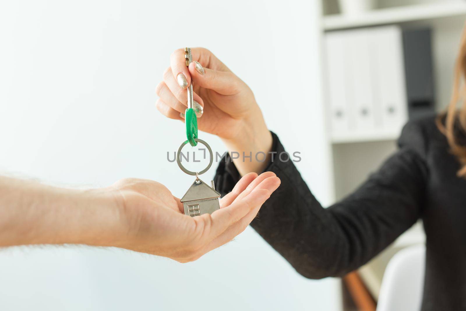 Business, realtor and real estate concept - Hand-to-hand key from new home.