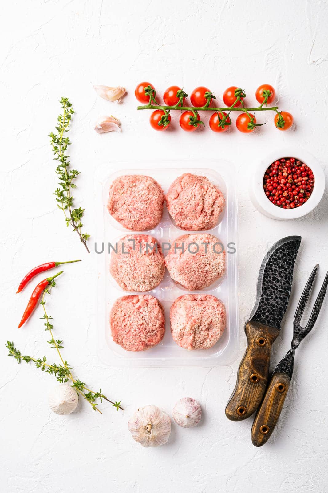 Semi finished products, meatballs, meat patties in plastic pack, on white stone table background, top view flat lay by Ilianesolenyi