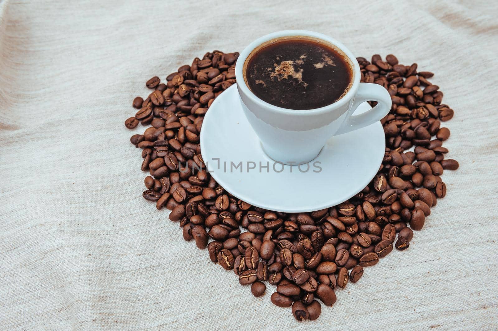 Cup of Coffe. Coffee beans in shape of heart. coffee beans isolated on white background. roasted coffee beans, can be used as a background. by Andrii_Ko