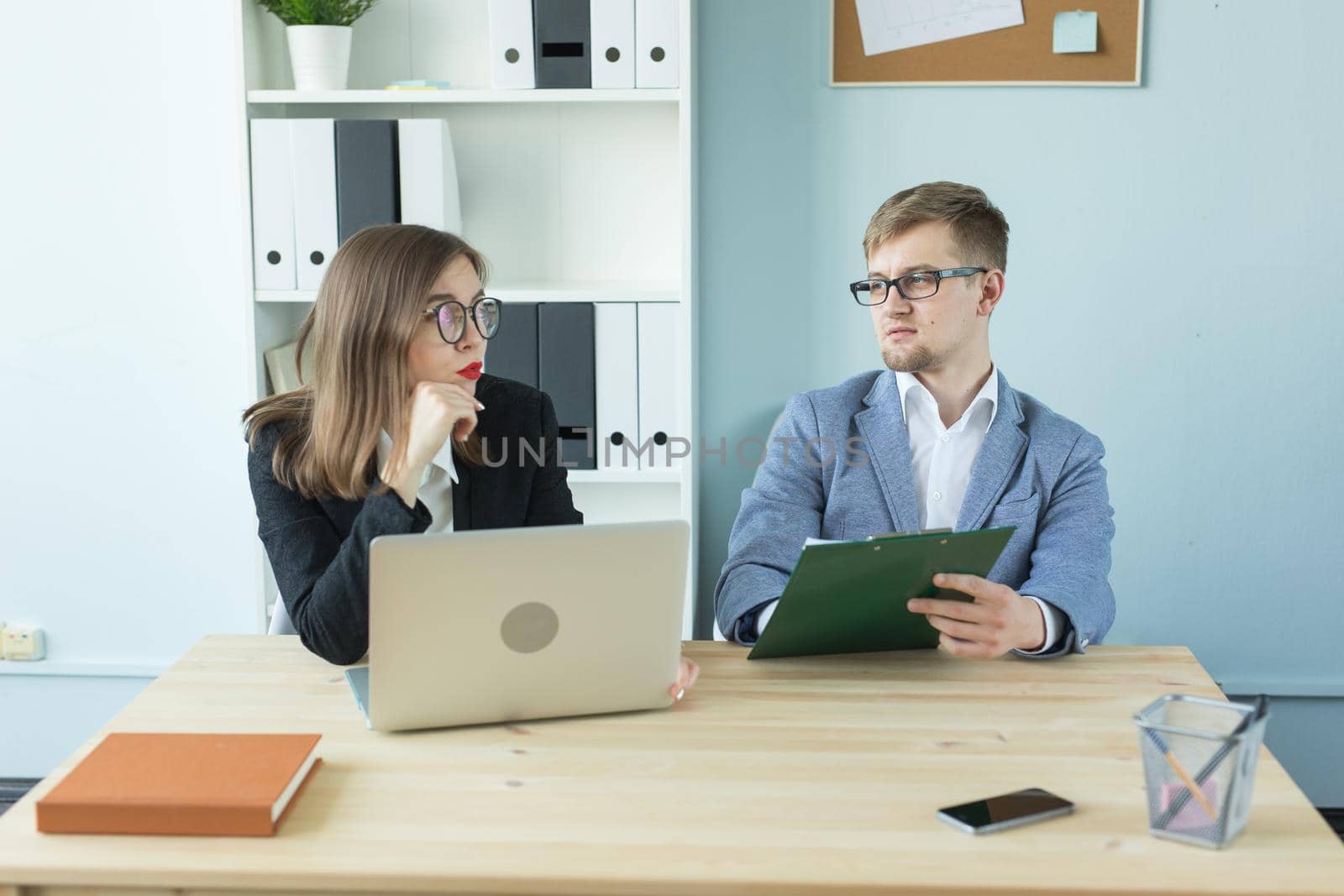 Business and people concept - Portrait of man and woman discussing project in office by Satura86