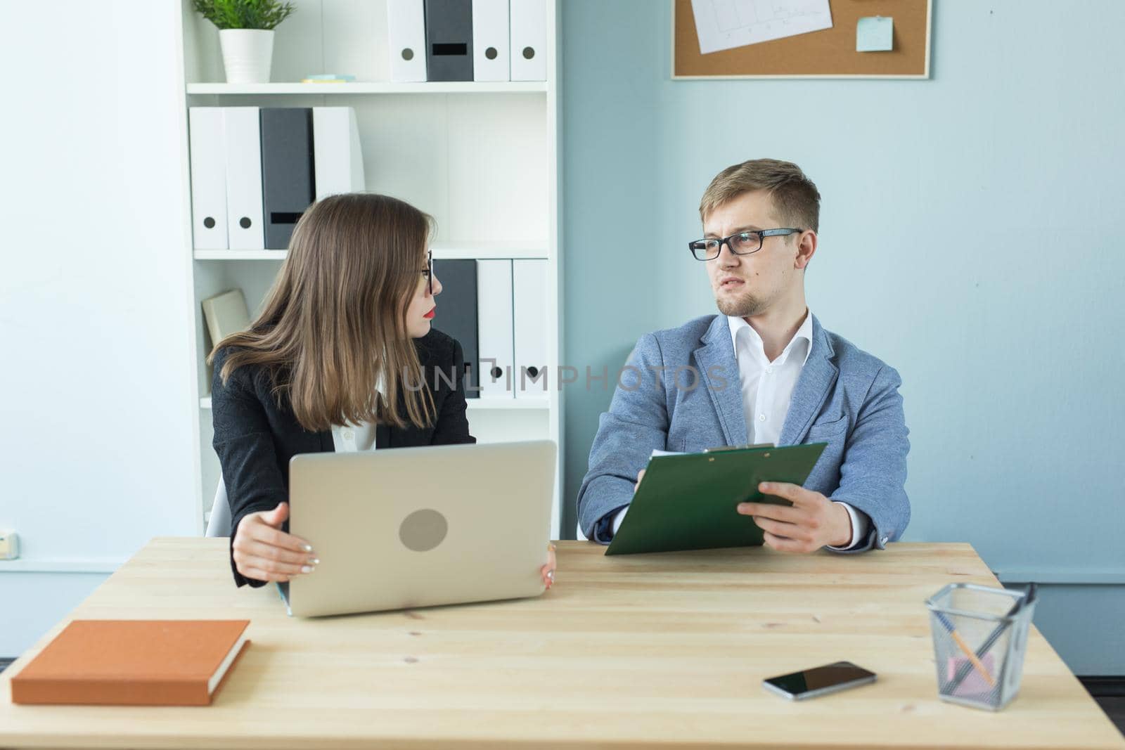 Business and people concept - Portrait of man and woman discussing project in office by Satura86