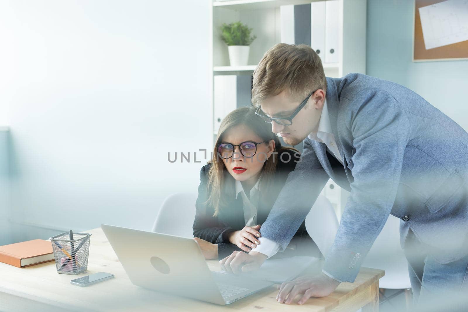 Business and people concept - Portrait of man and woman discussing project in office.