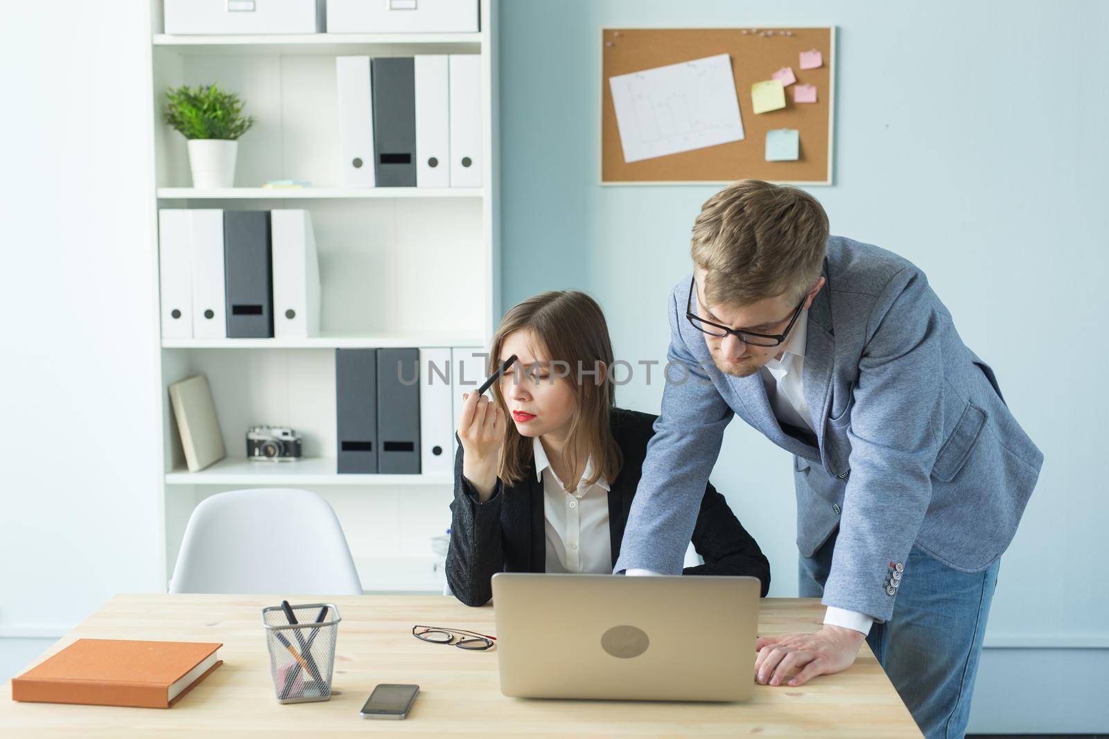 Business, teamwork and people concept - woman and man are working together in office.