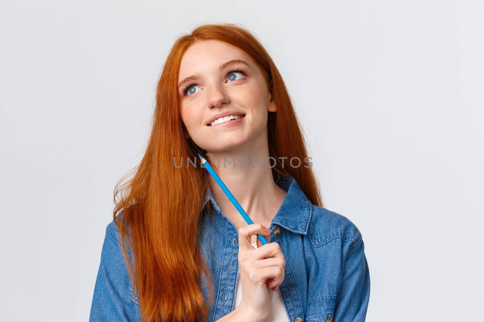 Lovely and creative, thoughtful dreamy smiling redhead woman looking up and thinking, imaging something beautiful, holding colored pencil, drawing, attend art courses, white background by Benzoix