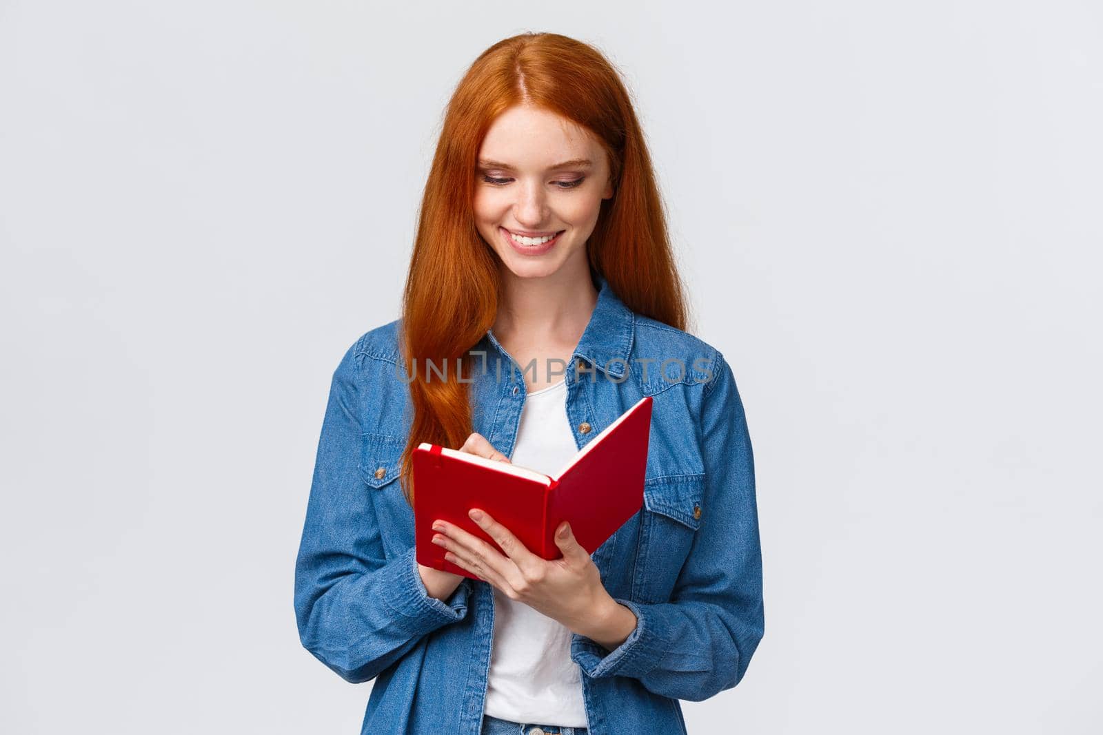 Creative and talented good-looking female college student prepare schedule for tomorrow classes, writing in diary, taking notes in fancy notebook, standing white background by Benzoix
