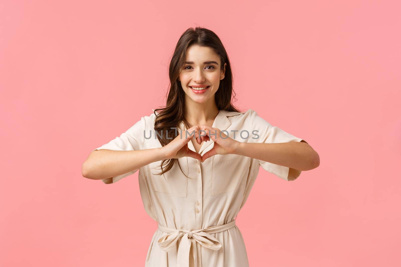 Waist-up portrait charming young brunette girl in dress, showing heart sign with love or care, absolutely adore boyfriend, having perfect relationship, feeling happy, smiling joyfully by Benzoix