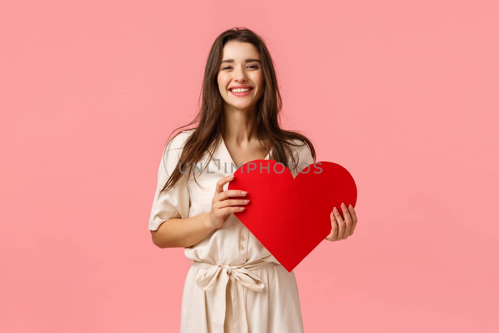 Silly and carefree, lovely alluring brunette girl in fancy dress, holding red big heart card, having best valentines day ever, smiling and laughing delighted, standing pink background upbeat by Benzoix