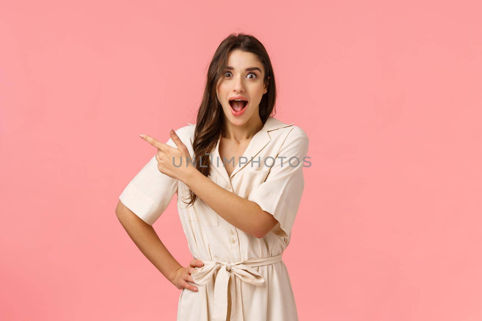 Wow amazing. Intrigued and astonished pretty happy european woman in spring dress, pointing upper left corner, smiling astonished and gasping wondered, curious about interesting advertisement by Benzoix