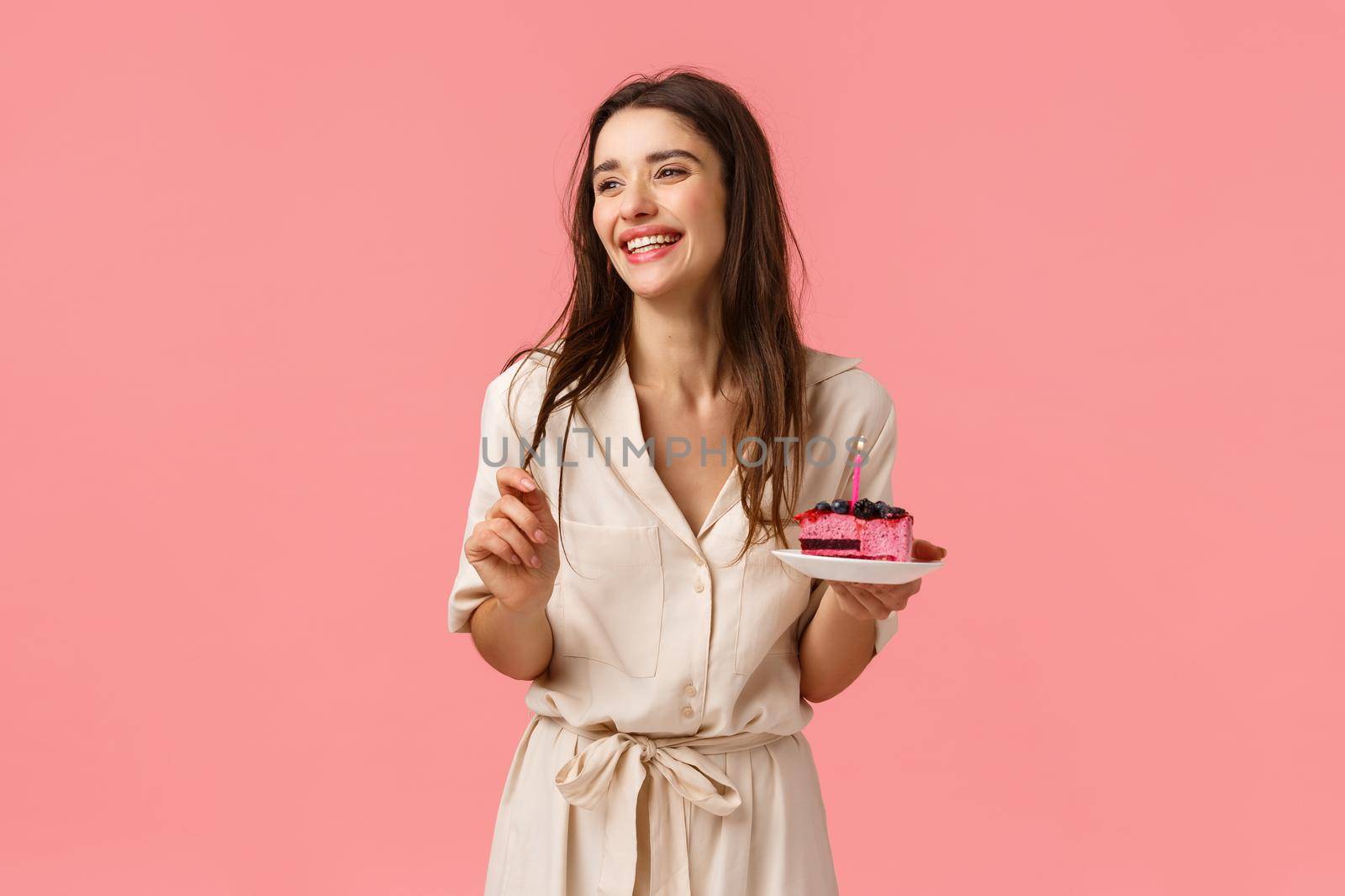Celebration, happiness and holidays concept. Beautiful young woman having fun, holding plate with cake, smiling and laughing carefree, eating b-day dessert blowing-out candle, having fun by Benzoix