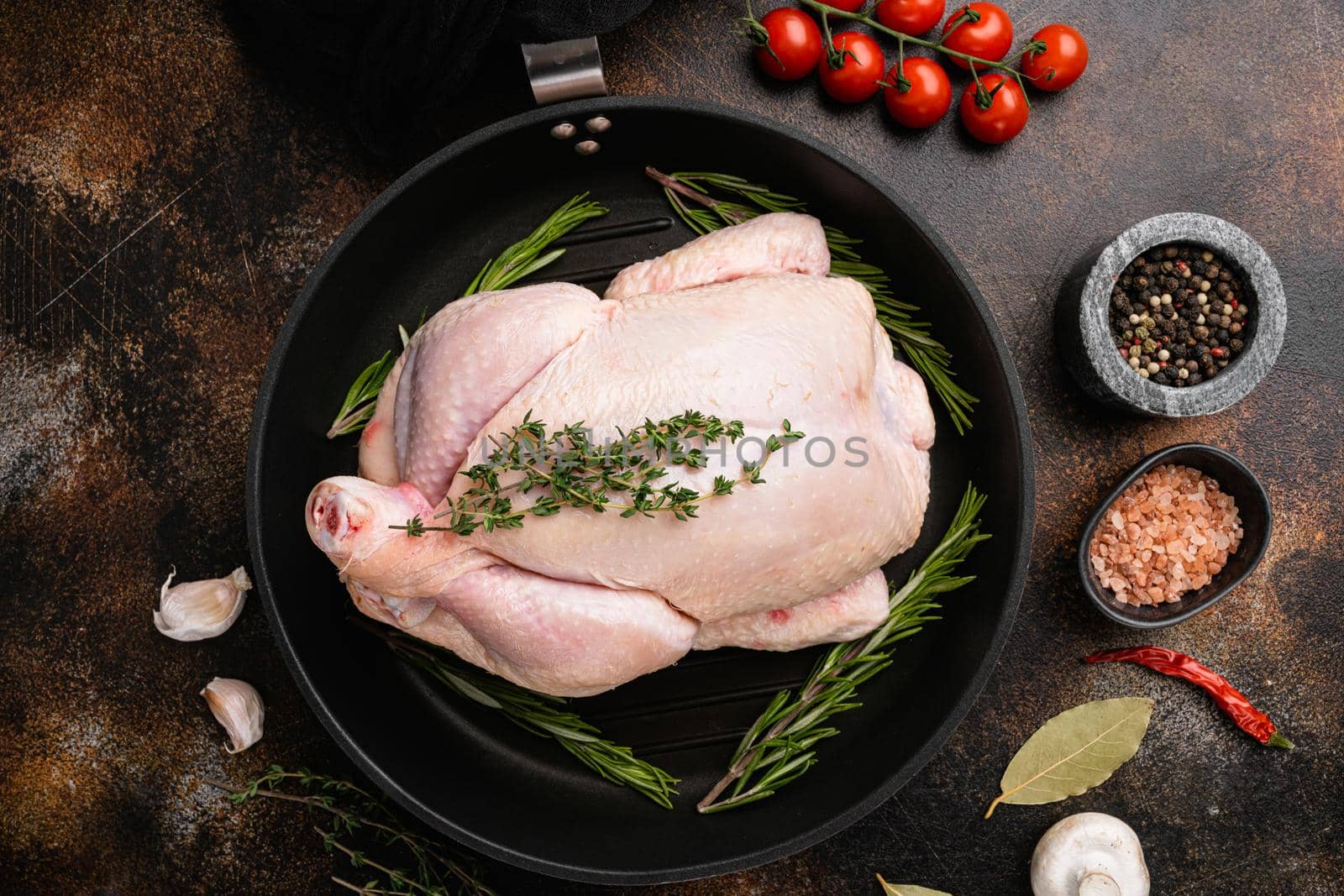 Whole raw free range chicken set, on old dark rustic table background, top view flat lay