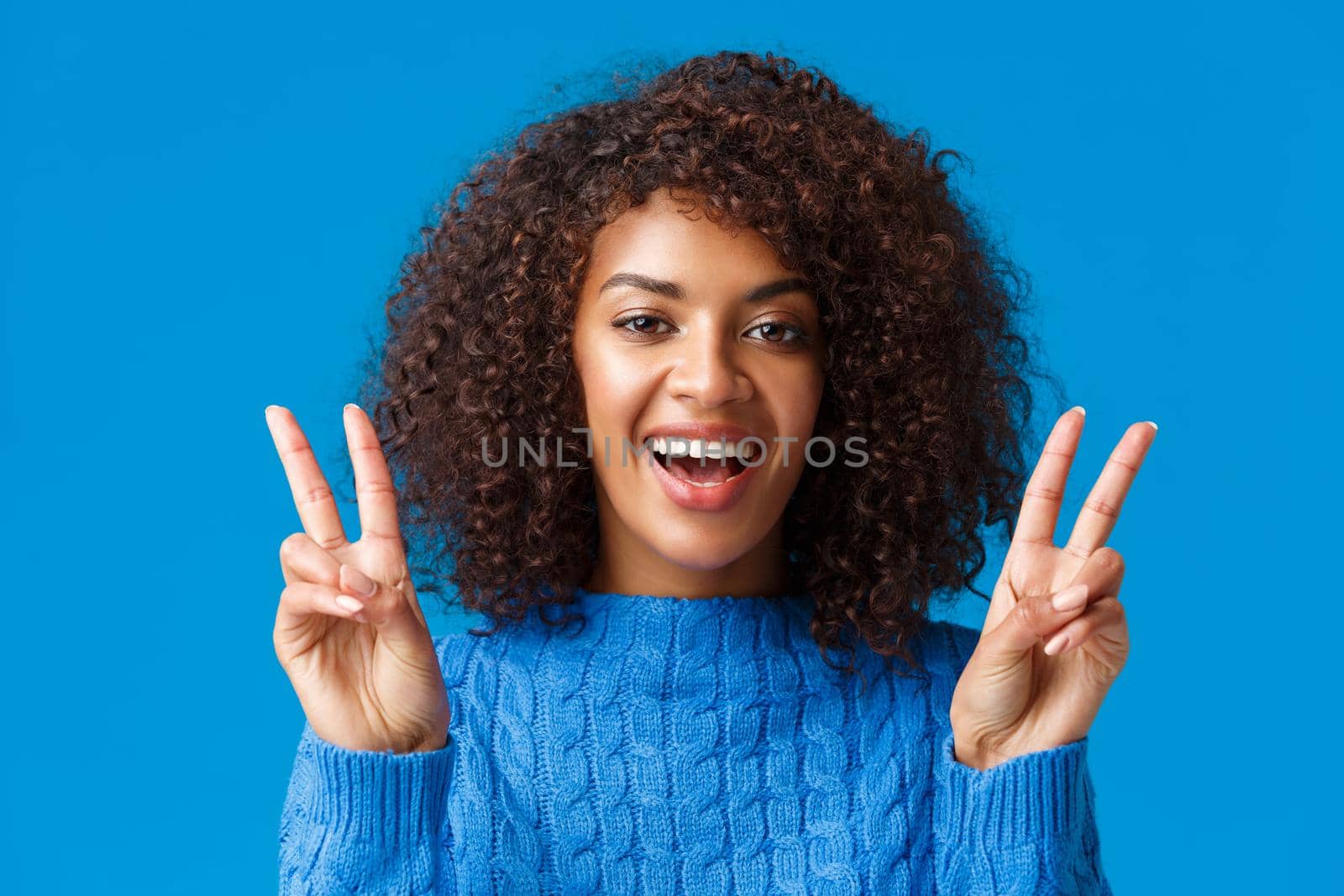 Charismatic excited and happy, smiling cheerful african american woman sending positive vibes, showing peace gesture and grinning, enjoying winter holidays, new year party, say cheese.