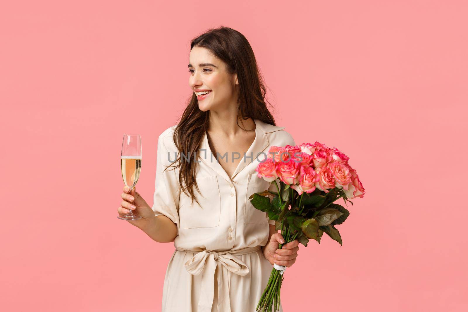 Elegance, celebration and party concept. Attractive young happy woman having birthday, receiving gifts, beautiful flowers, holding roses and champagne glass, smiling left, pink background by Benzoix