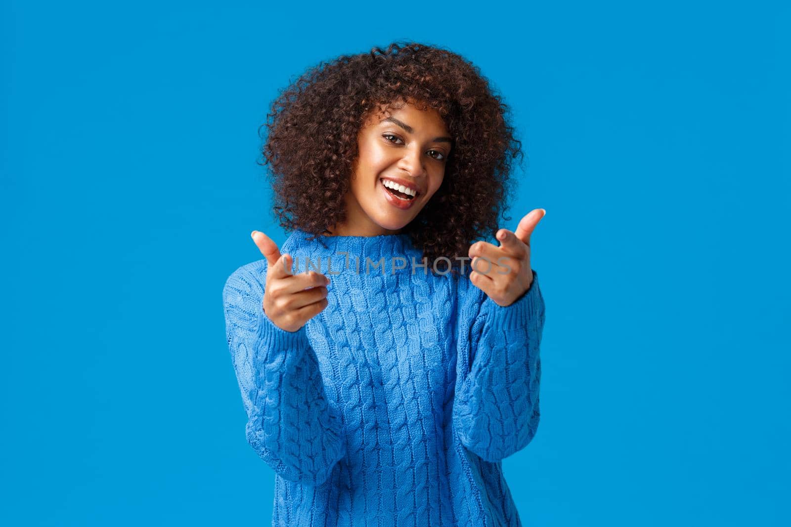 You cool, good job congratulations. Lucky cute african-american female with afro haircut, winter sweater, tilt head lovely smiling and pointing fingers camera as seeing friend and encourage her.