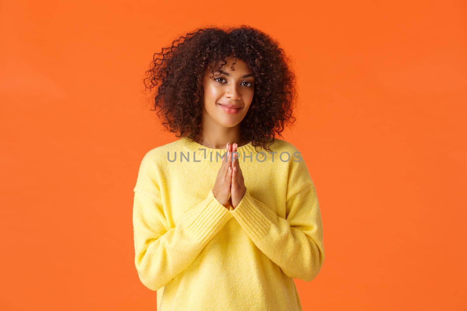 Girl feeling relish is near, something good will happen. Pleased and assertive, confident african-american woman clasp hands and smiling, awaiting, anticipating luck, orange background.