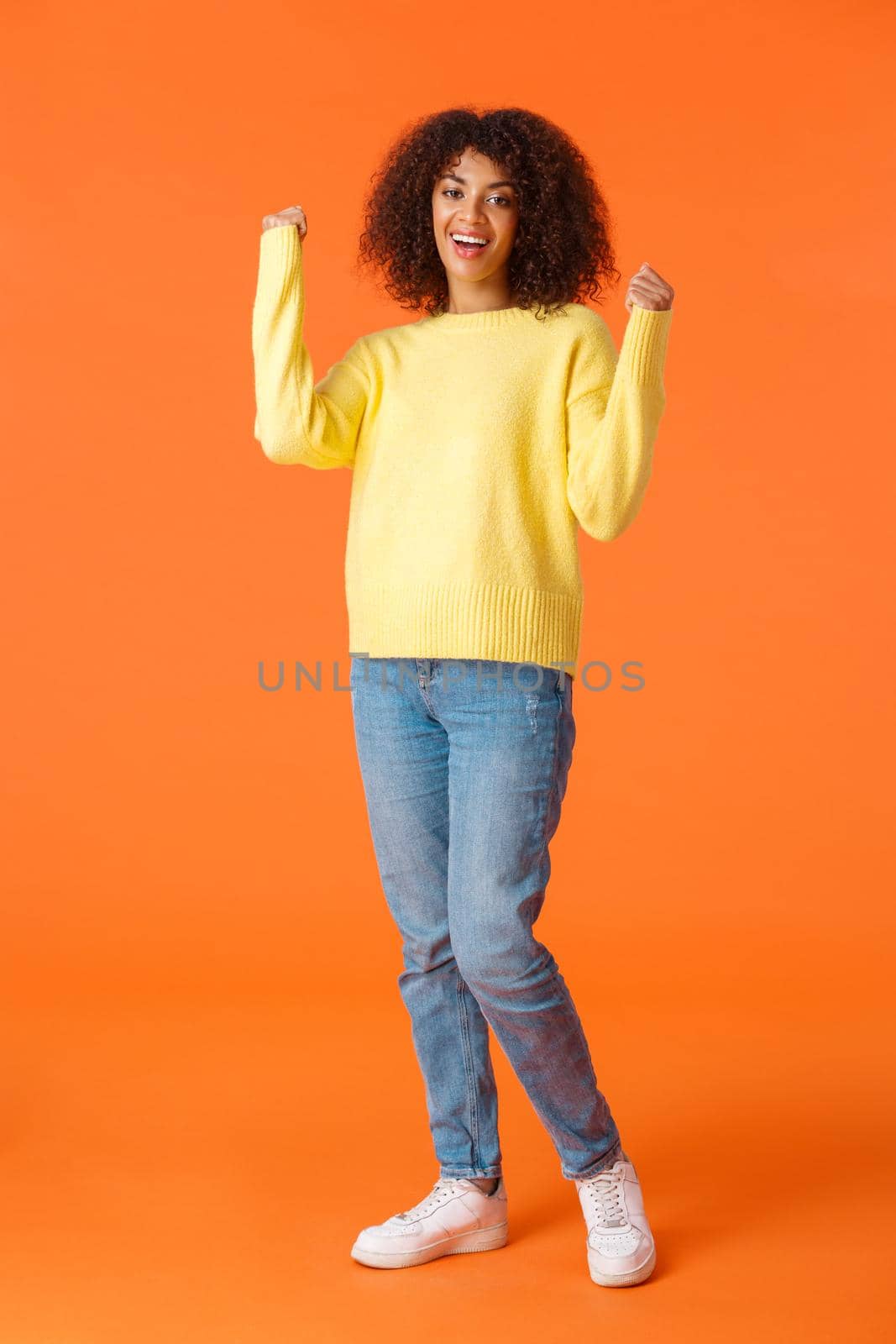 Full-length vertical shot lucky and emotive, excited good-looking girl african american female feeling like winner, fist pump and smiling satisfied, got approval, achieve goal, won prize by Benzoix