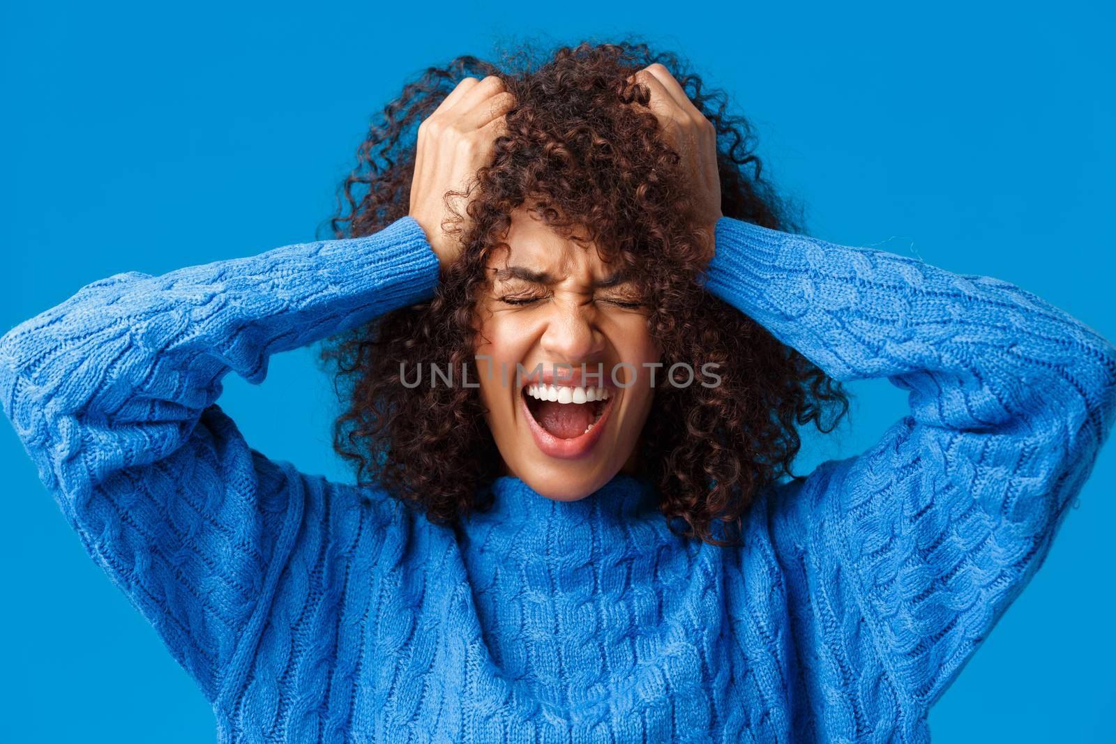 Close-up portrait distressed and tensed upset african-american woman screaming from feeling uneasy and let down, standing panicking and displeased over blue background close eyes shouting.