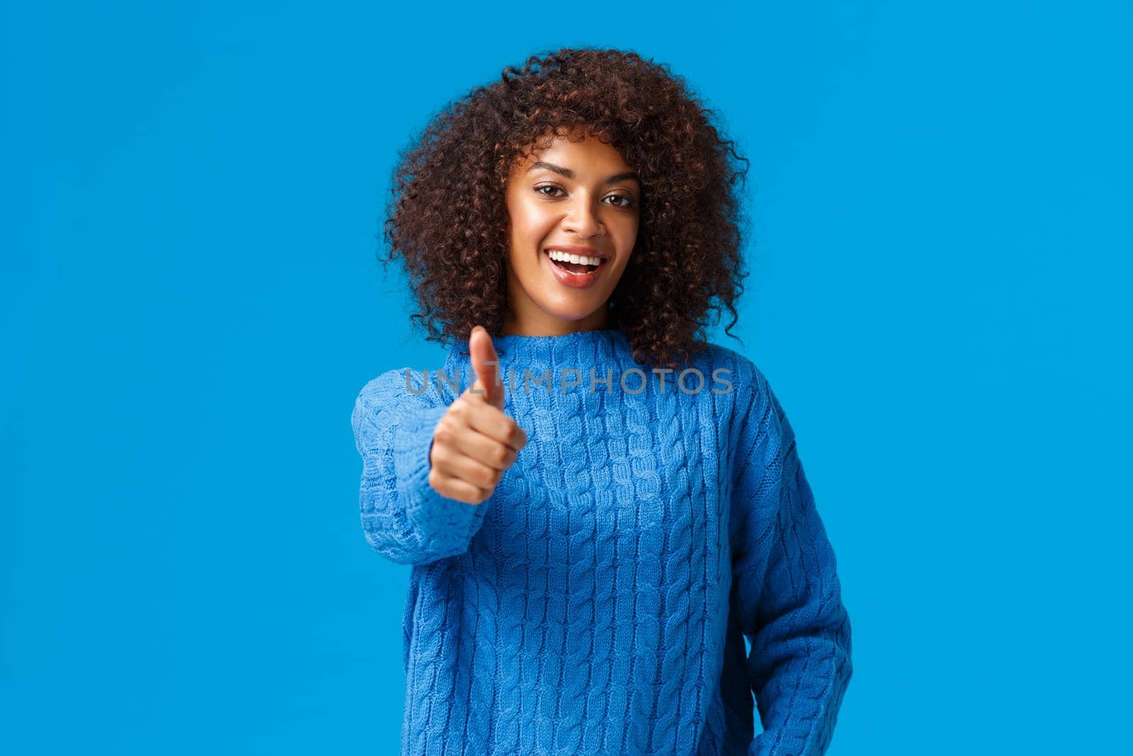 Waist-up portrait cheerful satisfied african american female with afro haircut, extend arm and showing thumb-up in approval, pleased good result, say yes or great job, praising someone.