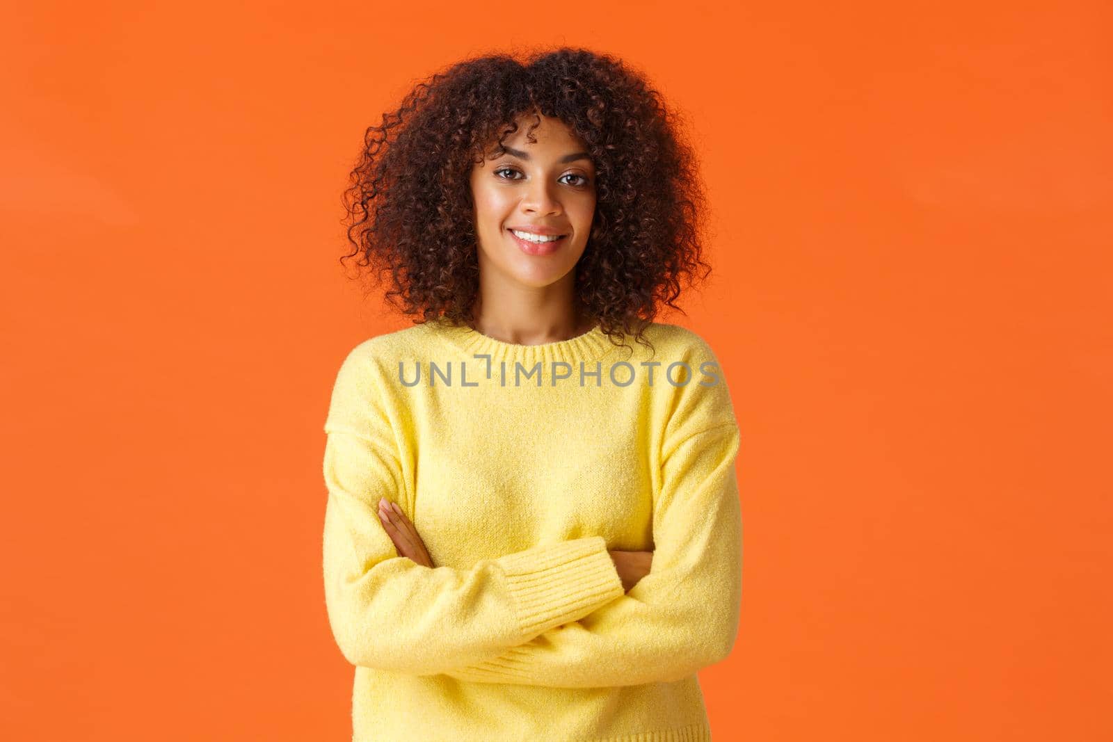 Professionalism, business and people concept. Pretty confident and creative african-american female coworker with curly hair, cross hands over chest, assertive and self-assured, smiling camera.