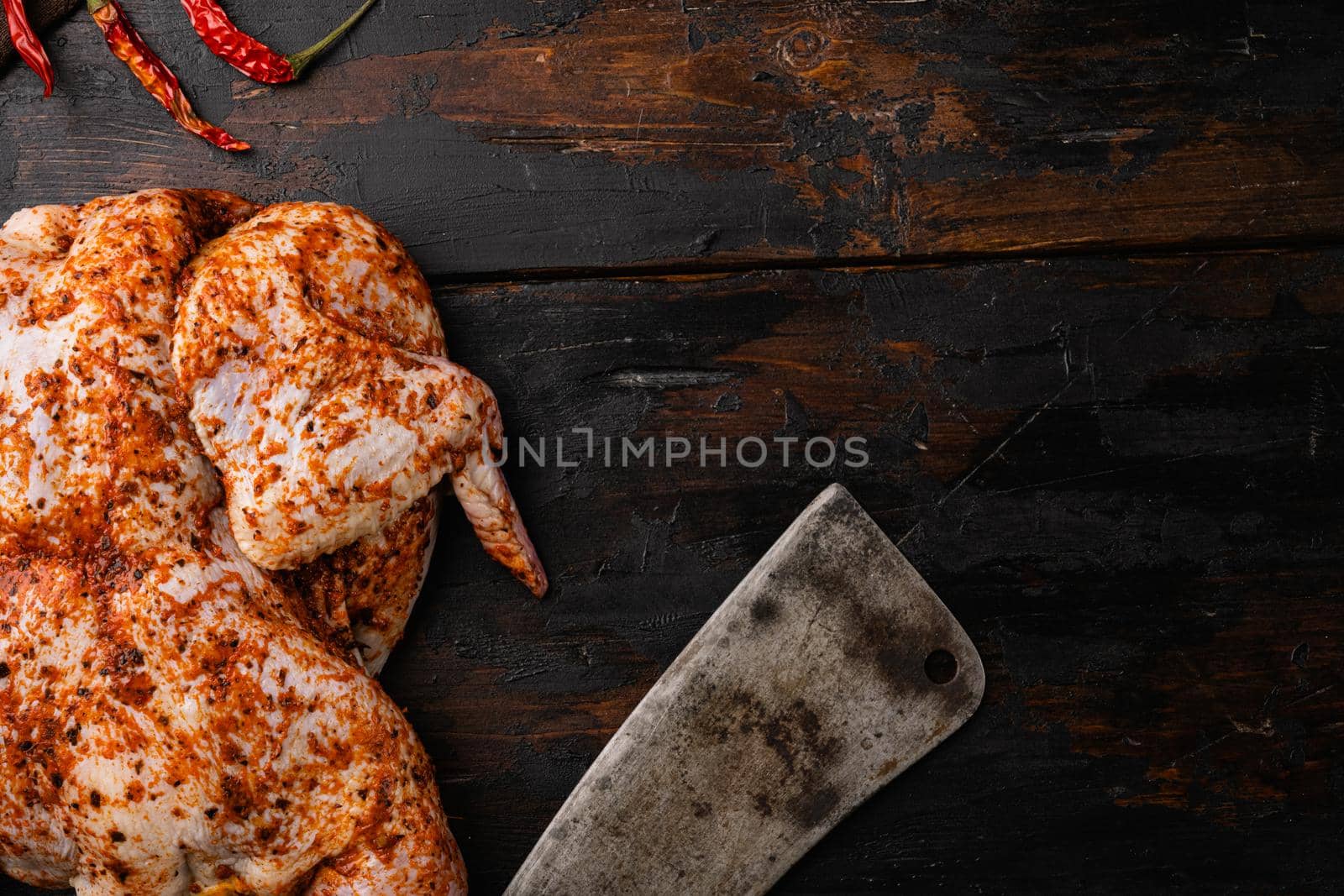 Raw chicken tabaka ready for cooking with ingredients set, on old dark wooden table background, top view flat lay, with copy space for text