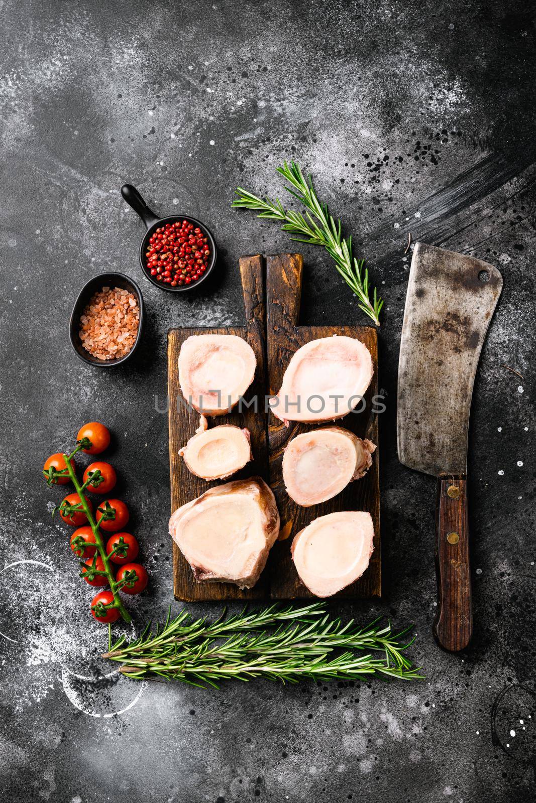 Raw beef marrow bones, on black dark stone table background, top view flat lay by Ilianesolenyi