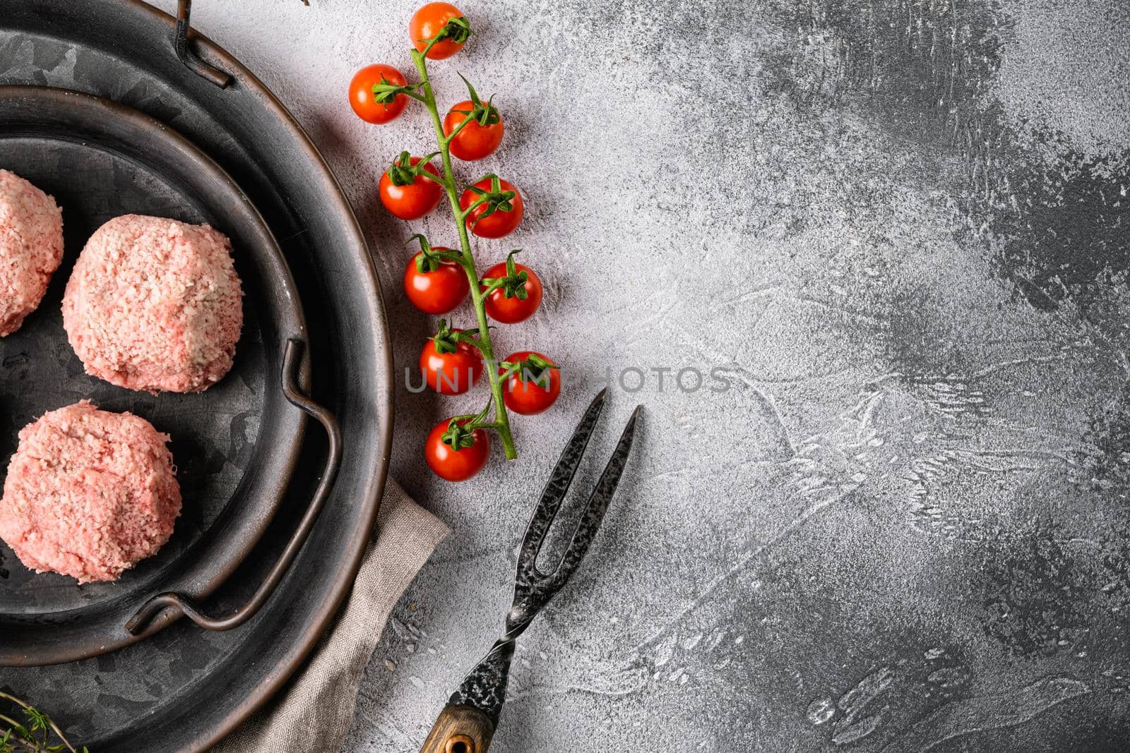 Raw ground beef meat steak cutlets set, on gray stone table background, top view flat lay, with copy space for text