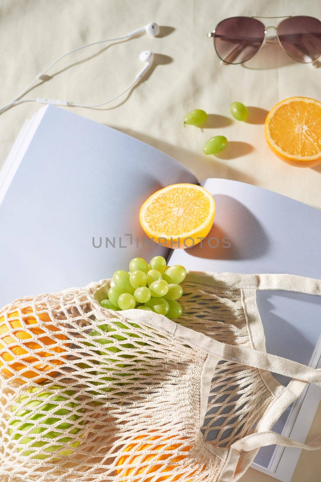 Summer holiday with fruit bag, glasses, earphone and magazine on light background. by makidotvn