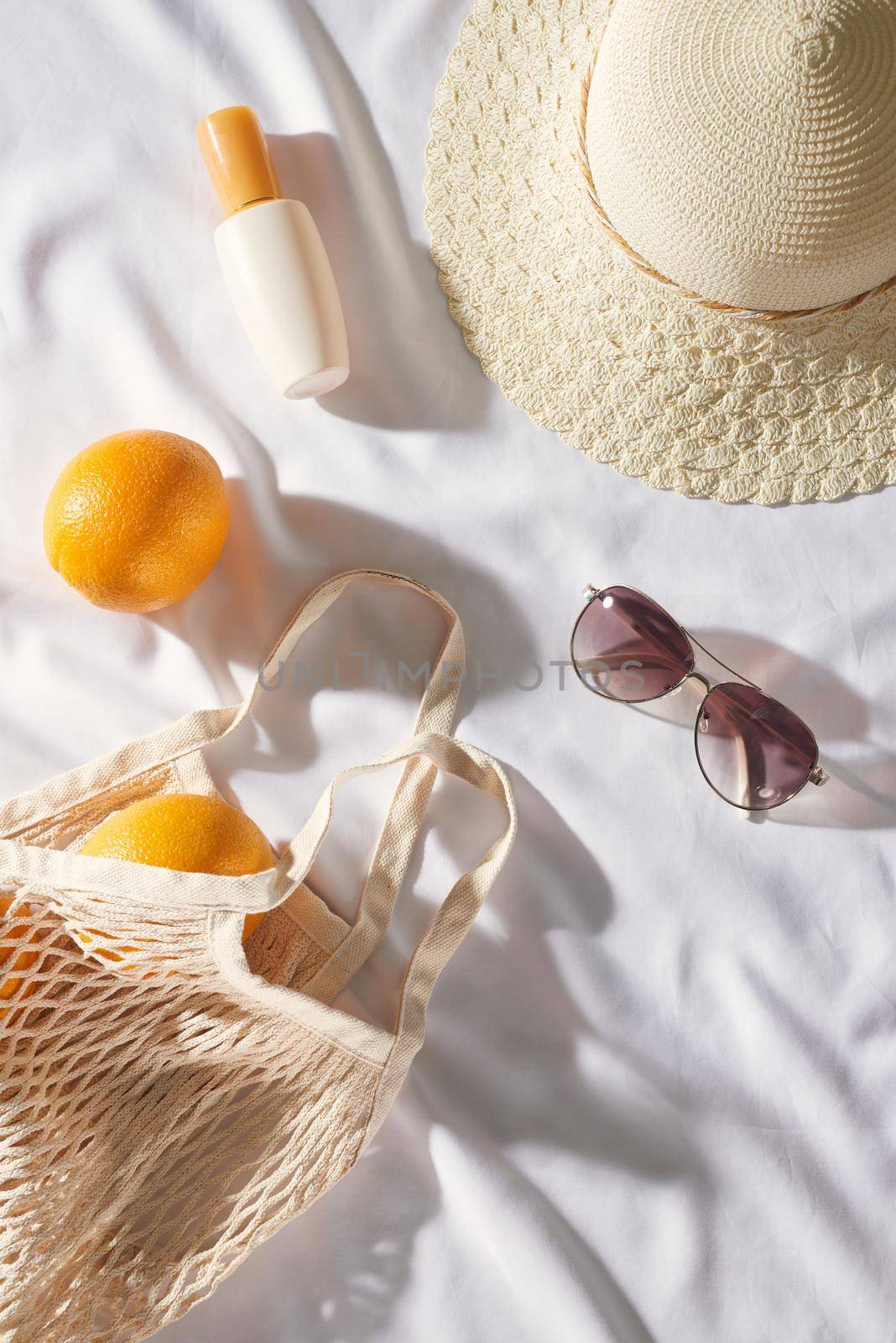 Flat lay Picnic, with glasses, an orange bag, sun cream and a straw hat with space. Summer mood by makidotvn