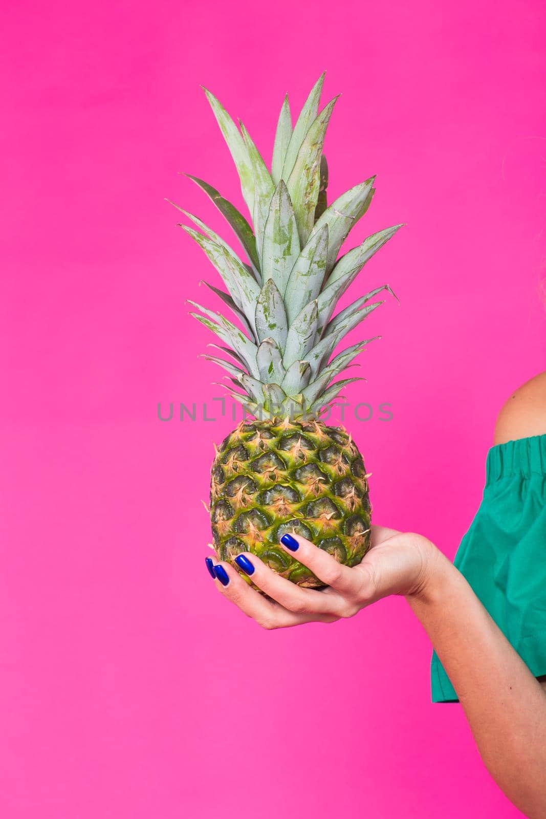 Closeup of woman and pineapple over pink background. Summer, diet and healthy lifestyle concept.